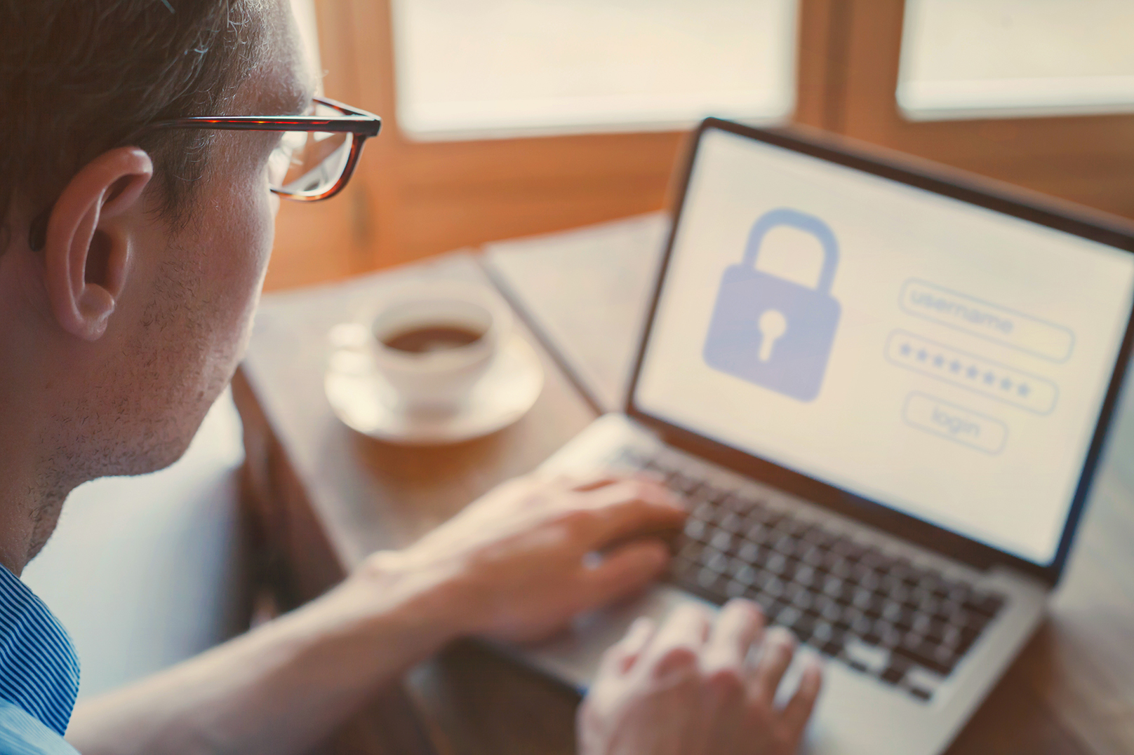 man looking at laptop with padlock on screen