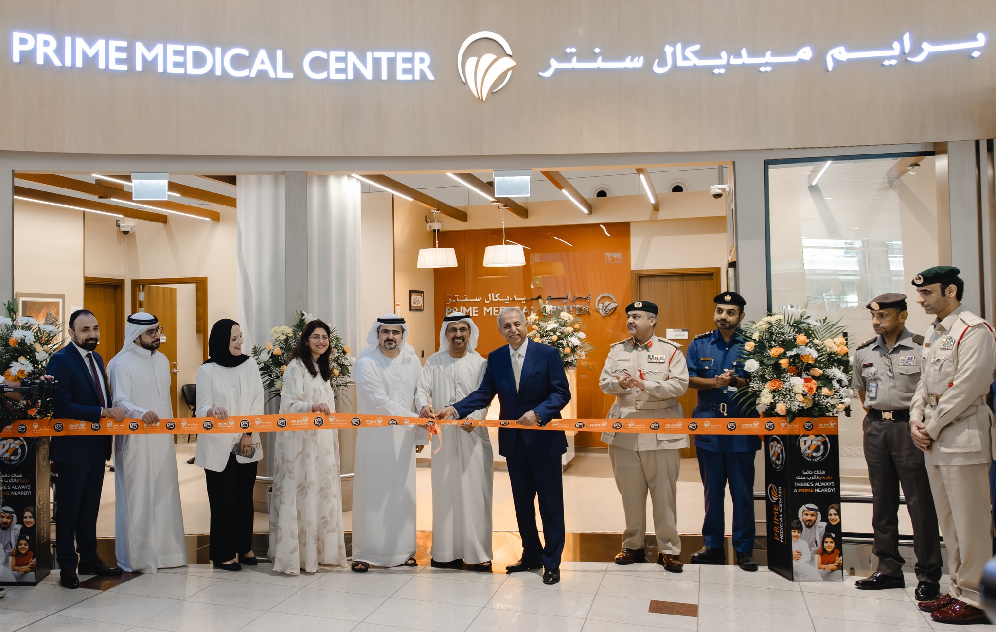 Group of people in formal attire at a ribbon-cutting ceremony in front of Prime Medical Center