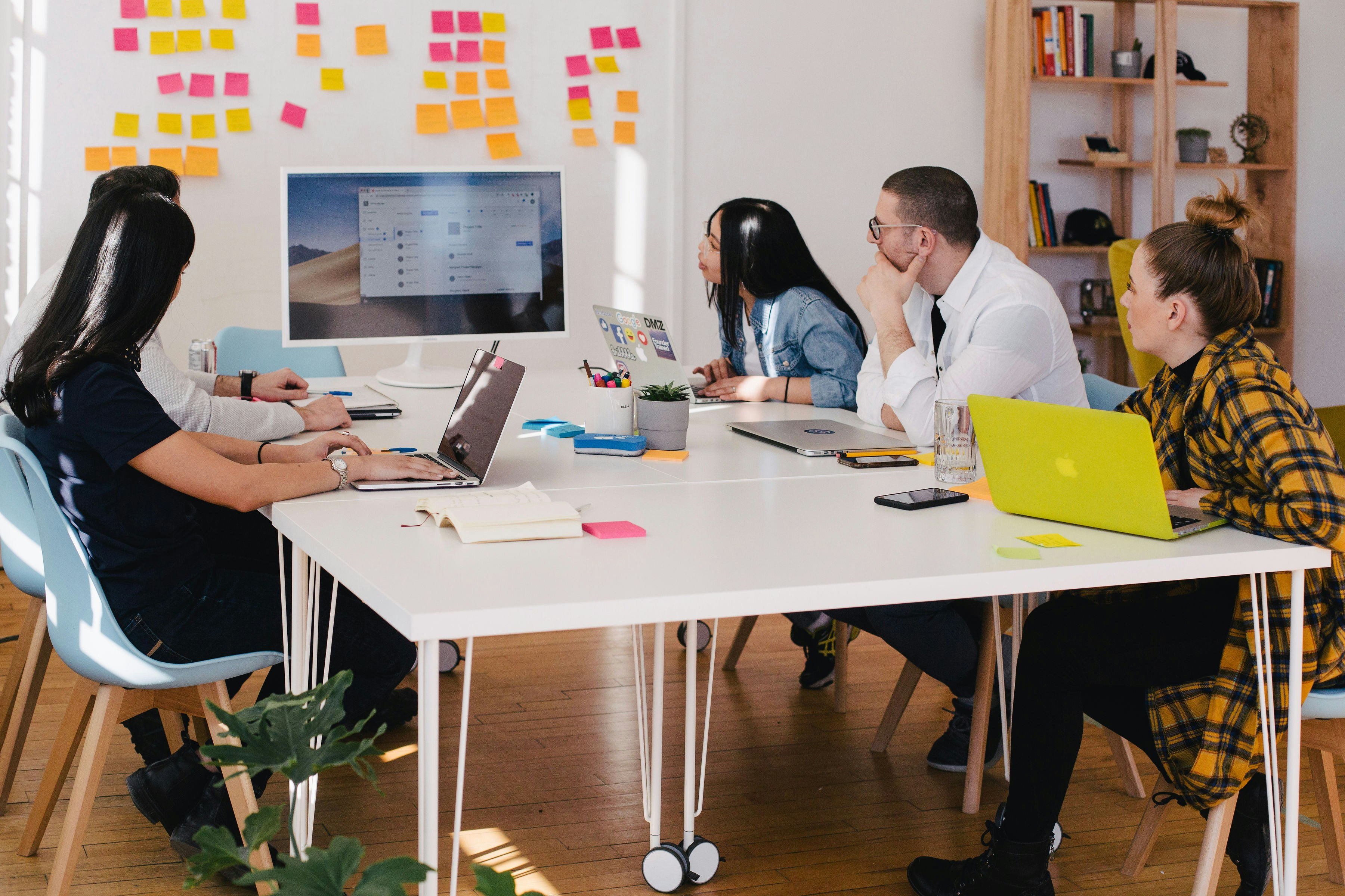Employees sitting at a desk and looking at a monitor